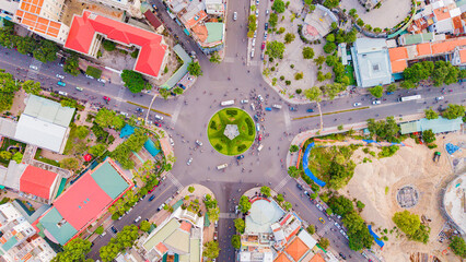 A difficult road intersection.

A drone shot from above of the intersection in Nha Trang in Vietnam of 7 roads. In the center of the intersection there is a flower bed in the shape of a star and a lig