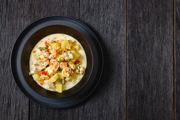 seafood chowder in a white bowl, top view