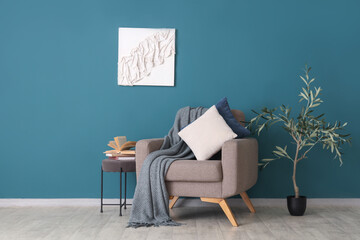Interior of living room with armchair and books on table