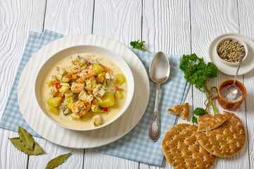 seafood chowder in a white bowl, top view