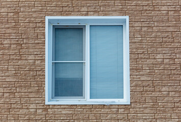 A window with a white frame and blue blinds