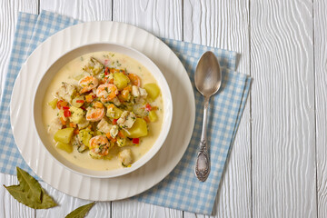 seafood chowder in a white bowl, top view