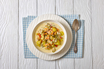 seafood chowder in a white bowl, top view