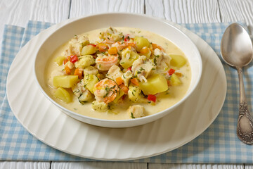seafood chowder in a white bowl, top view