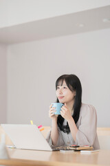 在宅での仕事中に休憩する女性