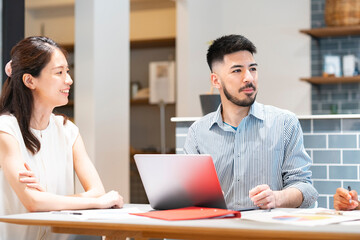 Obraz premium カジュアルな雰囲気のオフィス空間でミーティングするビジネスマンたち