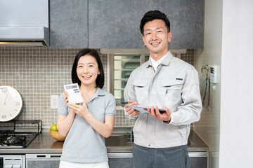 作業着の男性と電卓を持つ女性