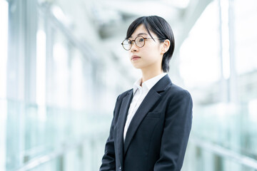 スーツを着て、緊張した表情をしている若い女性