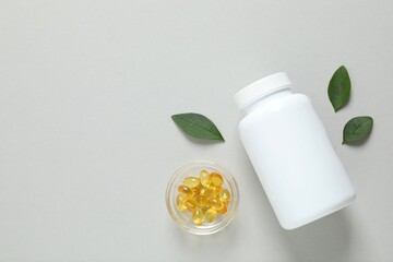 White bottle on a gray background. Fish oil tablets. Biologically active additives. Omega 3, 6,...