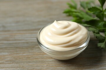 Bowl with mayonnaise and ingredients for cooking on wooden background