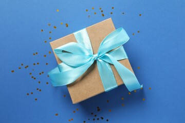 Beautiful gift box tied with bow on color background 