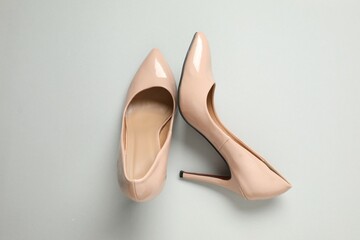 Stylish classic women's beige high heel shoes on color background. Top view, flat lay