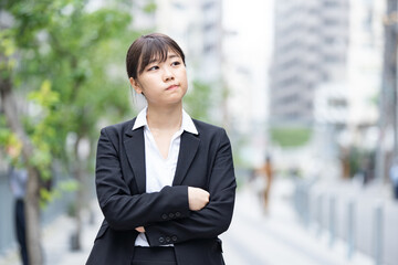 悩むスーツ姿の若い女性