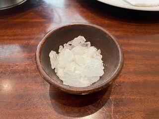 Rock Candy Crystals in a Dark Brown Wooden Bowl on a Polished Mahogany Table