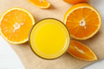 Glass of freshly squeezed orange juice on the table with citrus fruits