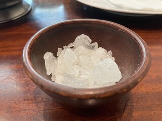Closeup of Rock Candy Crystals in a Dark Brown Bowl on Wooden Table