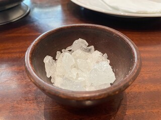 Closeup of Rock Candy Crystals in a Rustic Brown Bowl on a Wooden Table