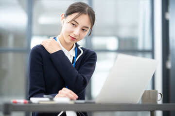 Fototapeta premium デスクワークで肩こりに悩む若い女性