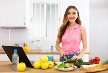 Woman cooking salad recipe from the Internet