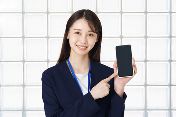 スマートフォンを操作するスーツ姿の女性