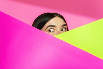 excited women peaking over color papers