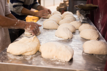 Male hands knead yeast dough for baking bread
