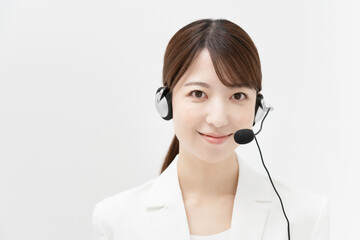 ヘッドセットを装着した白いスーツの女性