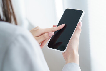 スマートフォンを操作するビジネスウーマン 