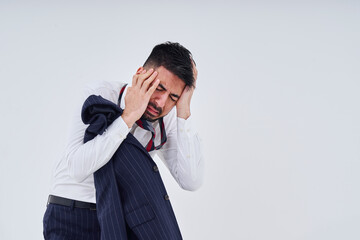 衣類が乱れてストレスを抱えた表情をするスーツ姿の男性