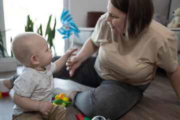 A truly heartwarming and delightful moment of interaction during joyful playtime between a loving mom and her baby