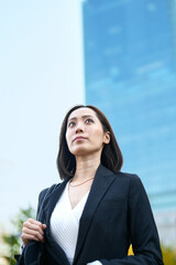 空を見上げるビジネスウーマン