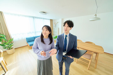 女性に部屋を説明するスーツ姿の男性