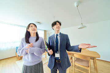 女性に部屋を説明するスーツ姿の男性