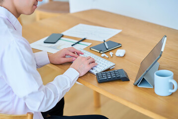 部屋でパソコンの操作をする男性の手元