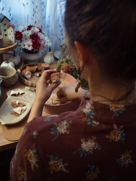 Woman stuffing Teddy toy with sawdust at her cozy desk