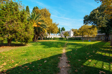 Obraz premium city park near the mosque, with a green lawn and trees, in the distance an old stone fence and buildings, Istanbul, Turkey