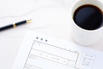 コーヒーを飲みながら、履歴書を書く
