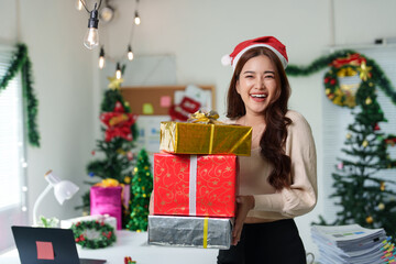 Confident Asian girl holding Christmas gift box in Santa hat smiling and holding presents. Christmas shopping and event ideas Celebration day during long holiday, party.