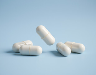 A Studio Shot of Antibiotic Pill or Capsules Falling on a Light Blue Background.