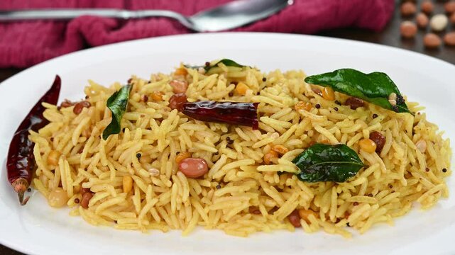 Serving tamarind rice on a white plate.