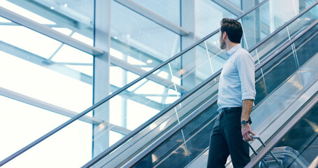 Businessman, escalator and travel at airport with luggage for flight, journey and thinking. Professional trip, worker and suitcase at lobby for arrival, immigration or airline broker with reflection