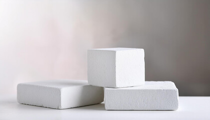 Three white stone blocks, empty podium. Pedestal for product presentation. Mock-up. Light backdrop