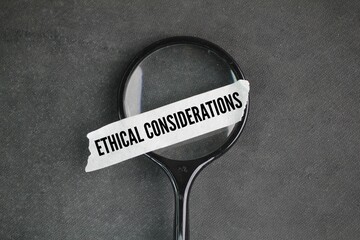 magnifying glass and a white sticker with the words Ethical considerations. principles that inform...