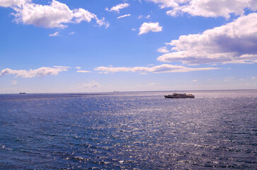  Several ships sail on a calm sea under a partly cloudy sky, capturing a serene maritime scene with open water