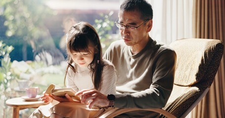 Father, girl and reading with book in living room with learning, language and education in family...
