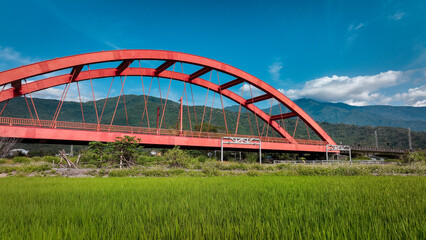 Obraz premium Kecheng Iron Bridge in Taiwan surrounded by lush greenery and distant mountains on a sunny day