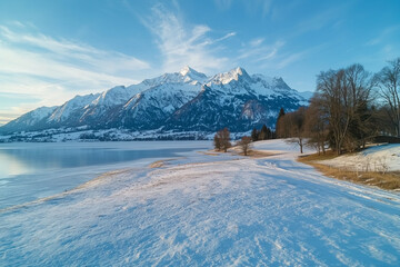 Frozen Serenity: Alpine Lake in the Embrace of Snowy Peaks