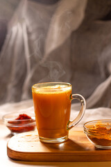 Steaming cup of herbal tea on wooden tray. Cozy atmosphere for winter evening. Concept of relax and didgital detox at home
