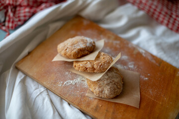 Homemade chicken cutlets arranged on a wooden board with parchment paper, styled in a rustic kitchen setting. Warm natural light and cozy details make it perfect for food photography or healthy meal c