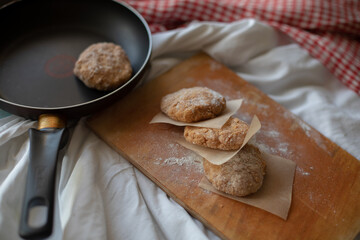 Homemade chicken cutlets arranged on a wooden board with parchment paper, styled in a rustic kitchen setting. Warm natural light and cozy details make it perfect for food photography or healthy meal c